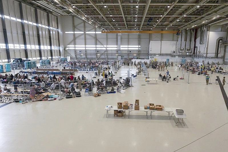 Für die Abfertigung von Passagieren, die zu ihrem nächsten Ziel transportiert werden sollen, wurde ein Wartungshangar in einen kleinen internationalen Flughafen umgewandelt. Foto: Senior Airman Taylor Slater/U.S. Air Force via AP/dpa