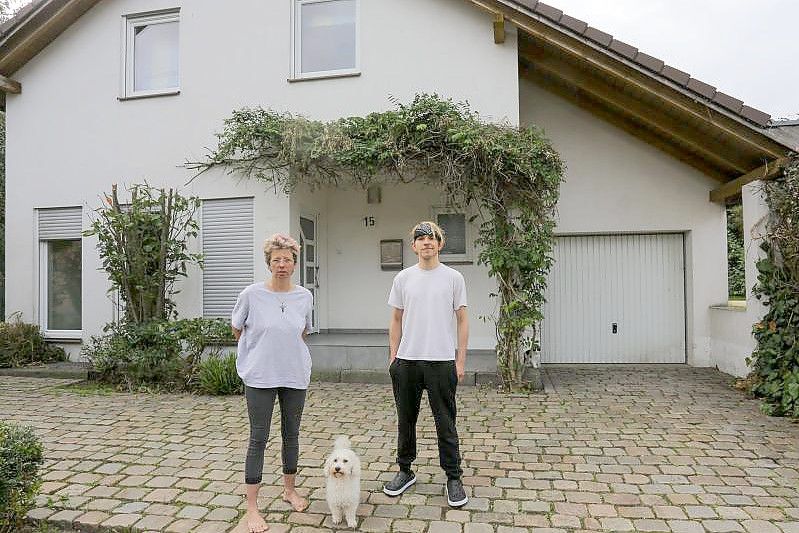 Anja Kassenpecher und ihr Sohn Dennis stehen vor ihrer vorübergehenden Bleibe im nordrhein-westfälischen Kuckum. Bei der Flutkatastrophe Mitte Juli wurde das Haus der Familie aus Ahrweiler zerstört. Foto: Ralf Roeger/dpa