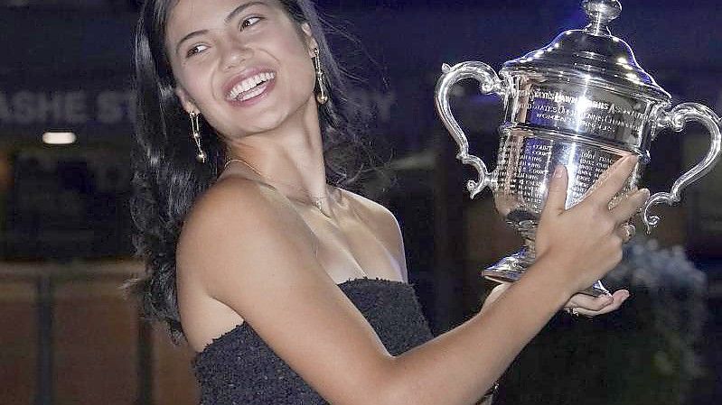 Die Britin Emma Raducanu posiert vor dem Arthur-Ashe-Stadion mit der Meisterschaftstrophäe. Foto: Elise Amendola/AP/dpa