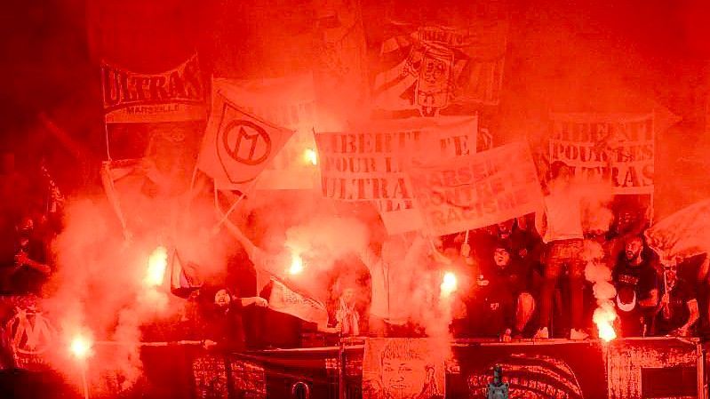 Fans von Marseille zünden Pyrotechnik während des Spiels in Angers. Nach dem Spiel gingen die Anhänger beider Clubs aufeinander los. Foto: Jean-Francois Monier/AFP/dpa