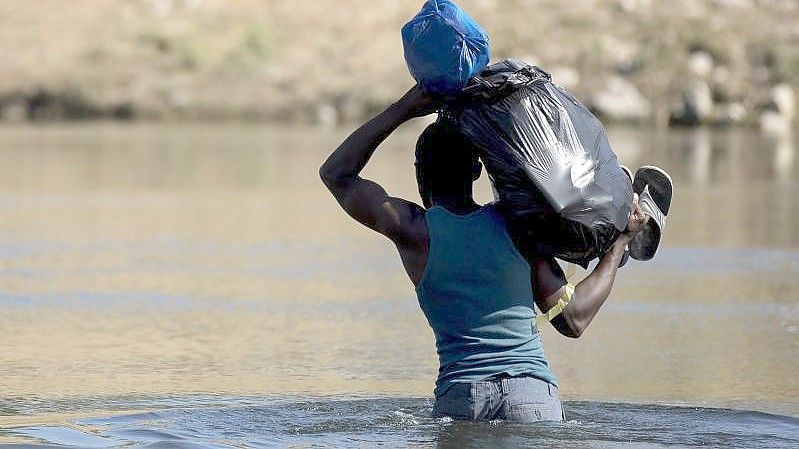 Ein haitianischer Migrant versucht den Fluss Rio Grande von Mexiko in die USA zu überqueren. Foto: Nick Wagner/XinHua/dpa