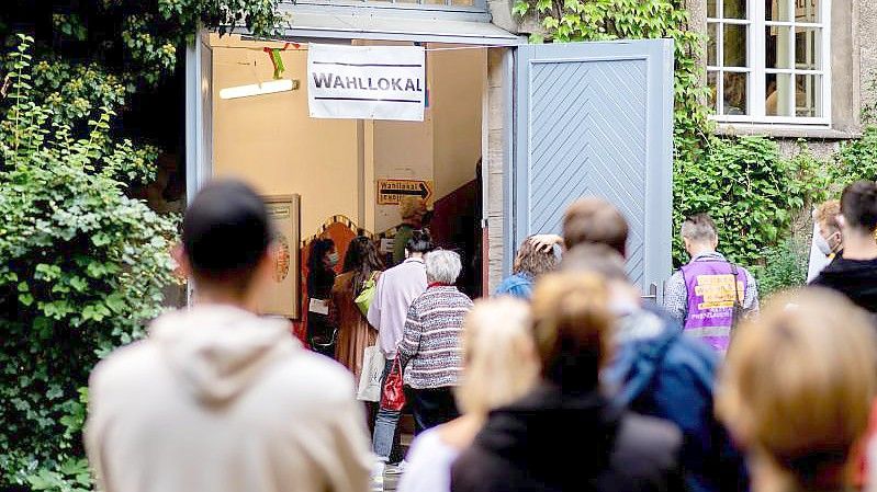 Zahlreiche Wählerinnen und Wähler warten im Stadtteil Prenzlauer Berg in einer langen Schlange vor einem Wahllokal, das in einer Grundschule untergebracht ist. Foto: Hauke-Christian Dittrich/dpa