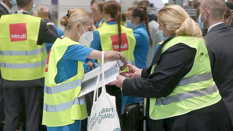 Personal der Eurowings steht beim Warnstreik mit verdi-Westen im Flughafen und trägt sich in Listen für Streikgeld ein. Foto: David Young/dpa