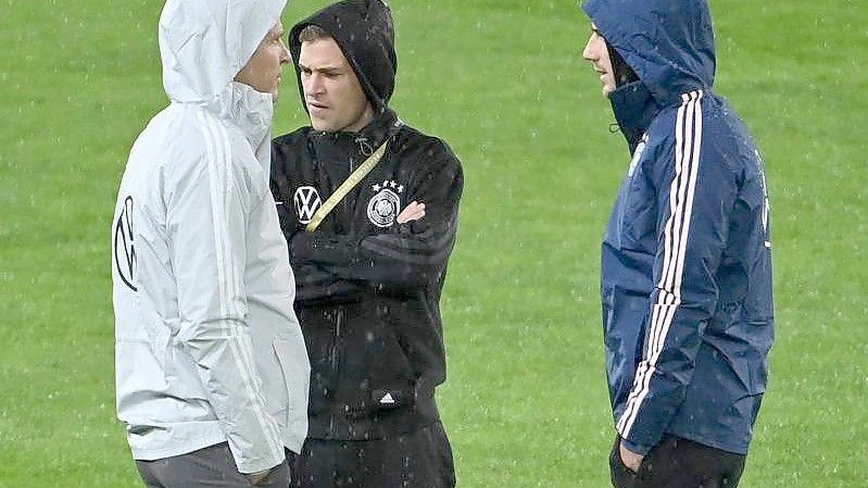 Oliver Bierhoff (l-r), Direktor Nationalmannschaften und Akademie, spricht mit Joshua Kimmich und Leon Goretzka vor dem Spiel auf dem Rasen. Foto: Federico Gambarini/dpa