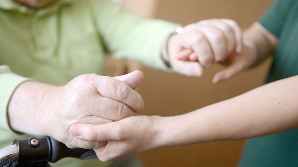 Eine junge Frau hält die Hände eines alten Mannes. Zwei von drei jungen Leute sind laut DAK-Pflegereport bereit, Angehörige zu pflegen. Foto: Jens Kalaene/dpa