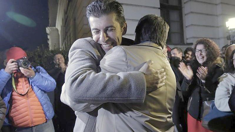 Kiril Petkow (l.) und Assen Wassilew von der Partei „Wir führen den Wandel fort“ liegen sich in den Armen. Foto: Valentina Petrova/AP/dpa