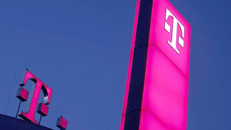 Das Logo der Deutschen Telekom leuchtet auf dem Dach der Unternehmenszentrale in Bonn. Foto: Oliver Berg/dpa