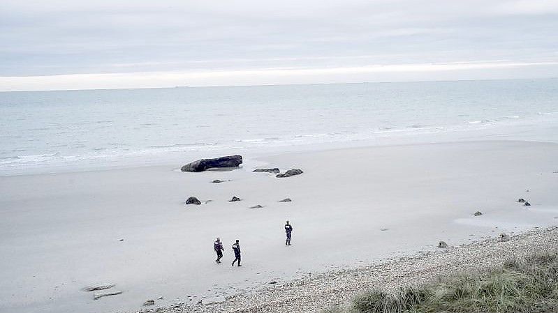 Französische Polizisten patrouillieren am Strand auf der Suche nach Migranten. Foto: Louis Witter/AP/dpa