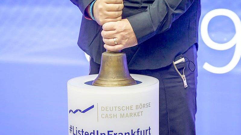 Jan Bredack, der Vorstandsvorsitzende Veganz Group AG, hält nach dem Börsengang des Berliner Herstellers von veganen Lebensmitteln die Glocke in der Frankfurter Börse fest in den Händen. Foto: Frank Rumpenhorst/dpa