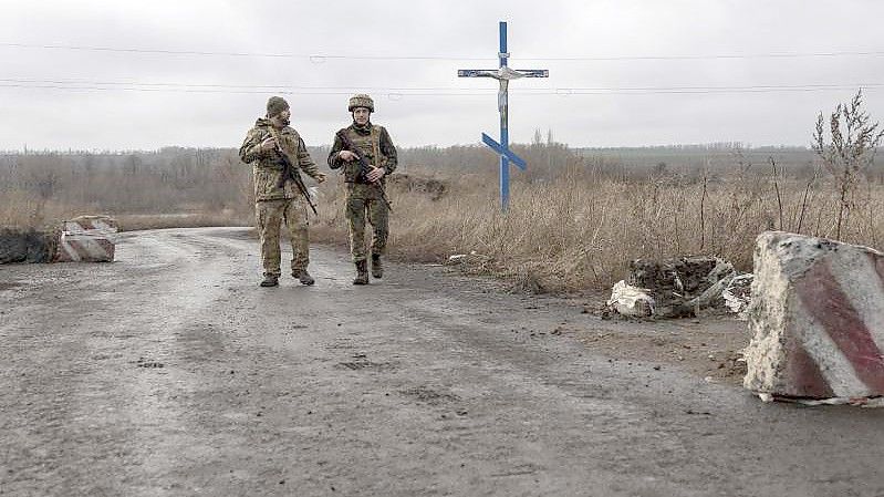 Ukrainische Soldaten gehen an der Trennlinie zu den von Russland unterstützten Rebellen in der Nähe des Dorfes Nevelske in der Ostukraine entlang. Foto: Andriy Dubchak/AP/dpa/Archiv