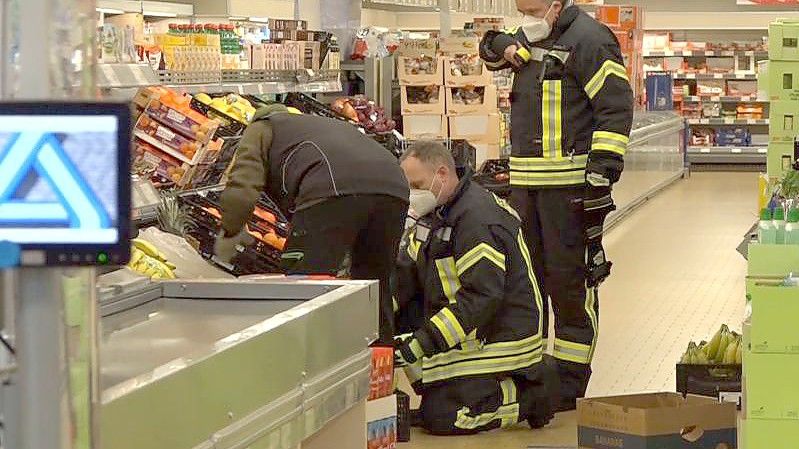 Einsatzkräfte der Polizei, Feuerwehr und ein Spinnenexperte suchen in Obst- und Gemüseregalen nach der Spinne. Foto: Nord-West-Media/Nord-West-Media /dpa