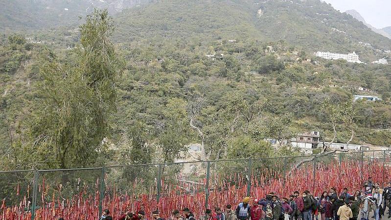 Hinduistische Gläubige stellen sich nach einer tödlichen Massenpanik in einer Reihe auf, um zur heiligen Höhle des Mata Vaishnav Devi-Schreins zu wandern. Foto: Channi Anand/AP/dpa