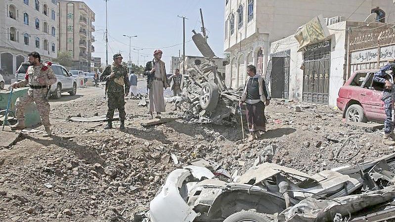 Polizisten stehen im November 2021 am Ort eines saudi-geführten Luftangriffs in Sanaa. Foto: Hani Al-Ansi/dpa