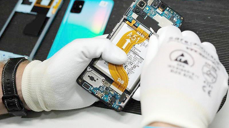 Reparatur eines Mobiltelefones in der Werkstatt der Komsa AG. Verbraucherschützer fordern die Bundesregierung dazu auf, das geplante Recht auf Reparatur bis Mitte März auf den Weg zu bringen. Foto: Sebastian Willnow/dpa-Zentralbild/dpa