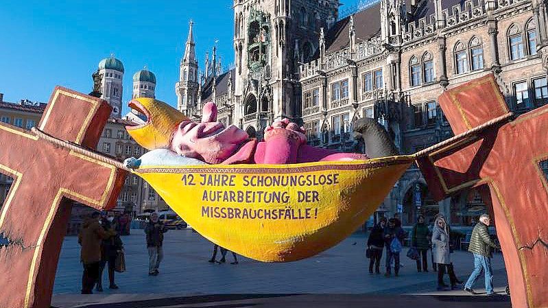 Die Plastik „Der Hängemattenbischof“ steht auf dem Marienplatz in München. Foto: Sven Hoppe/dpa