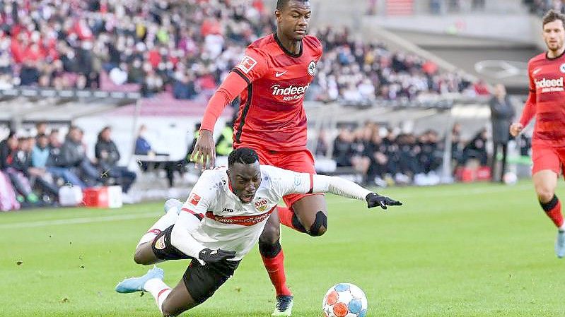 Stuttgarts Silas (l) fällt neben Evan Ndicka aus Frankfurt auf den Rasen. Foto: Silas Stein/dpa