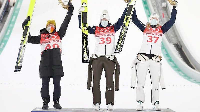 Skispringerin Katharina Althaus (l) freut sich bei der Siegerehrung über ihre Silbermedaile. Foto: Daniel Karmann/dpa