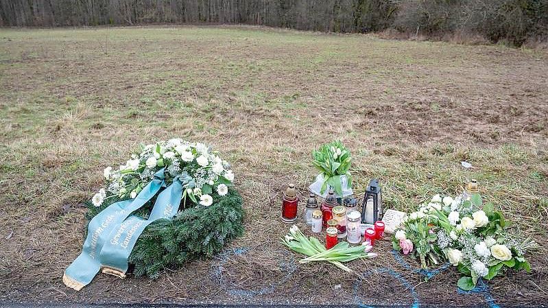 Ein Kranz sowie Blumen und Kerzen liegen am Tatort an der Kreisstraße 22 bei Ulmet (Rheinland-Pfalz). Foto: Harald Tittel/dpa