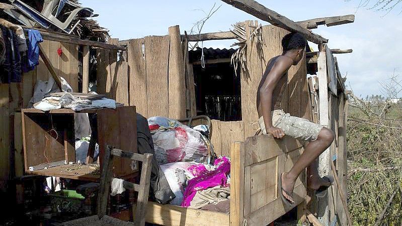 Ein Mann vor den Überresten eines Hauses. Foto: Viviene Rakotoarivony/AP/dpa