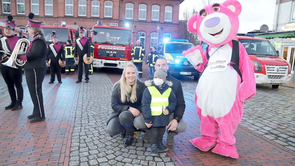 Um auf die Situation des an Leukämie erkrankten Lenny aufmerksam zu machen, haben Einsatzkräfte von Polizei, Feuerwehr und dem Deutschen Roten Kreuz am Freitag Alarm geschlagen. Das Foto zeigt Lenny mit seinen Eltern Lidia Egert und Raphael Schrantz sowie dem DrumBär von der der „Drum und Marching Band“ aus Augustfehn. Fotos: Passmann