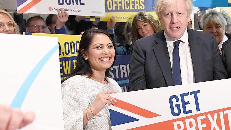 Der britische Premierminister Boris Johnson neben Innenministerin Priti Patel. Foto: Stefan Rousseau/PA Wire/dpa/Archivbild