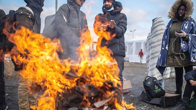 Mehrere Menschen wärmen sich an einem Feuer am Grenzübergang zwischen Polen und der Ukraine. Foto: Alejandro Martínez Vélez/EUROPA PRESS/dpa