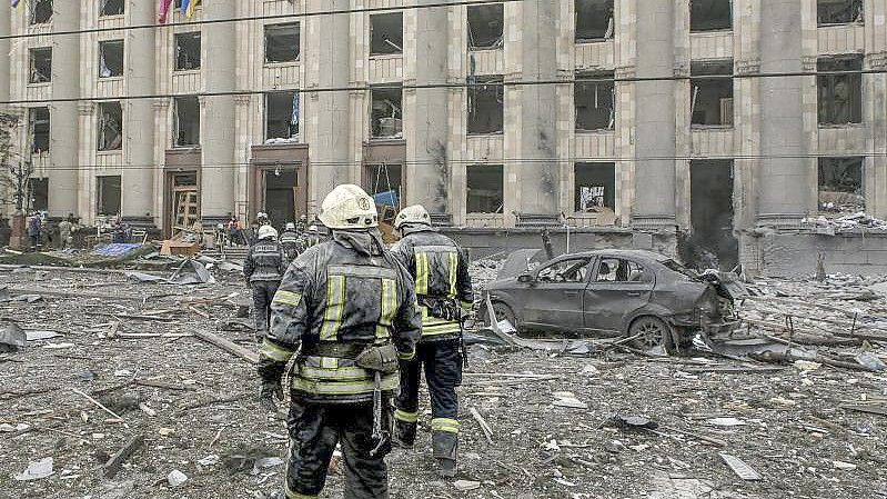 Ukrainische Rettungskräfte arbeiten vor dem beschädigten Rathausgebäude in Charkiw nach dem russischen Beschuss. Foto: Pavel Dorogoy/AP/dpa