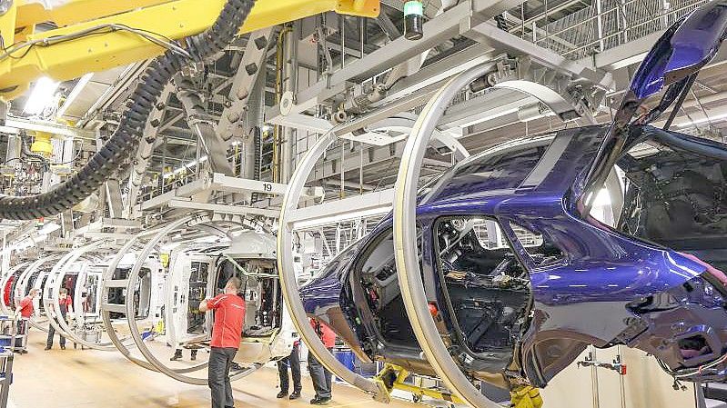 Mitarbeiter montieren Komponenten an Porsche Macan und Panamera im Leipziger Werk. Foto: Jan Woitas/dpa-Zentralbild/dpa