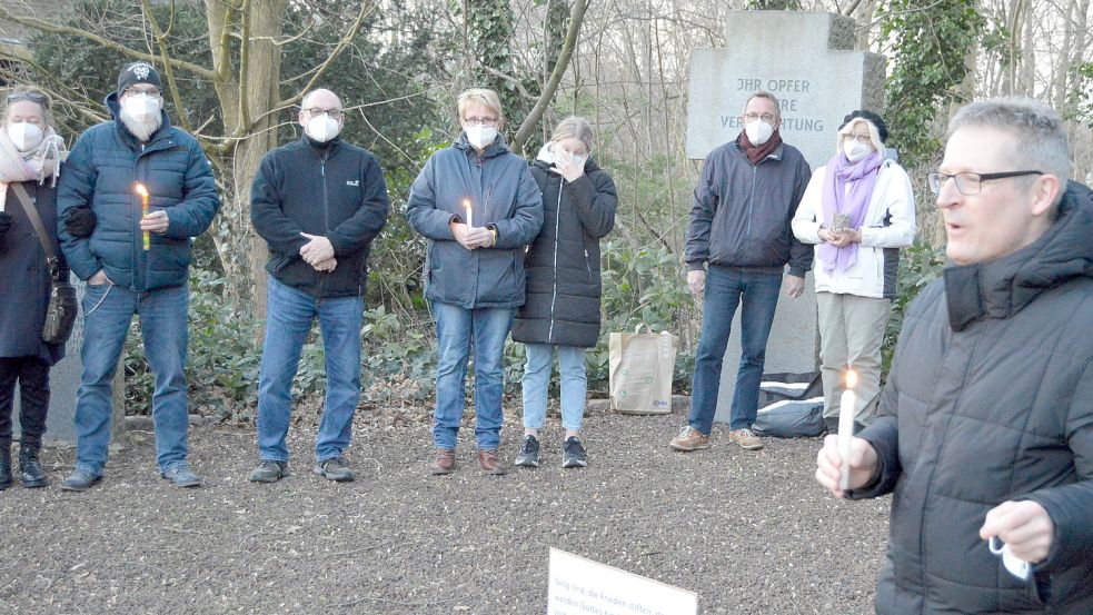 Das Foto zeigt Idafehns Pastor Florian Bortfeldt (rechts) mit einigen Teilnehmern der Mahnwache. Foto: Weers