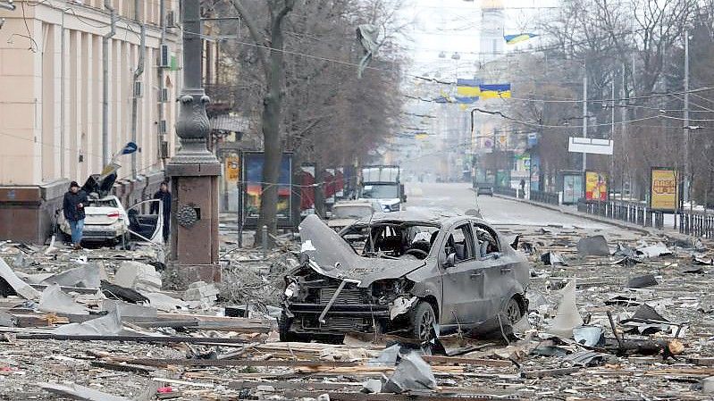 Ein ausgebranntes Autos in der Nähe des durch Angriffe zerstörten Gebäudes der regionalen Verwaltung von Charkiw. Foto: ---/Ukrinform/dpa