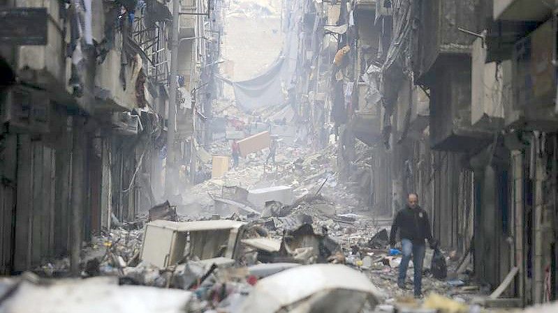 In einem östlichen Stadtteil von Aleppo fliehen Menschen vor dem Krieg (Archivbild). Foto: Hassan Ammar/AP/dpa