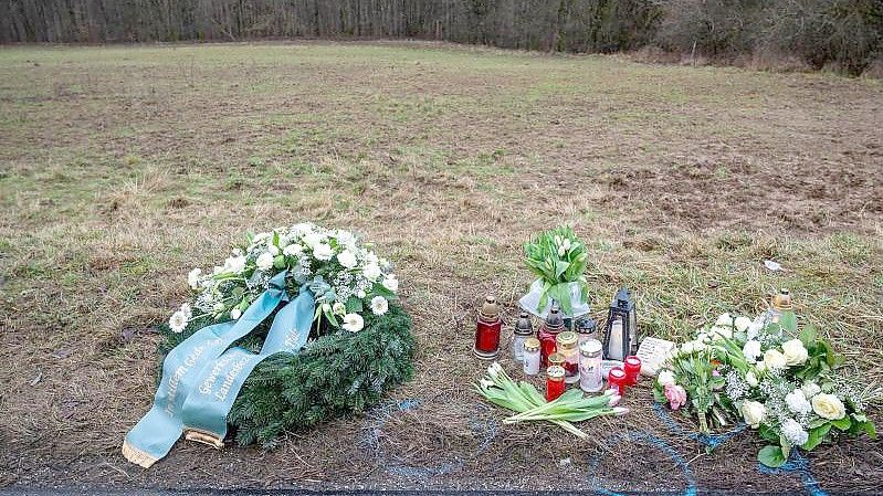 Ein Kranz sowie Blumen und Kerzen liegen am Tatort in Rheinland-Pfalz, wo zwei junge Polizisten getötet wurden. Foto: Harald Tittel/dpa