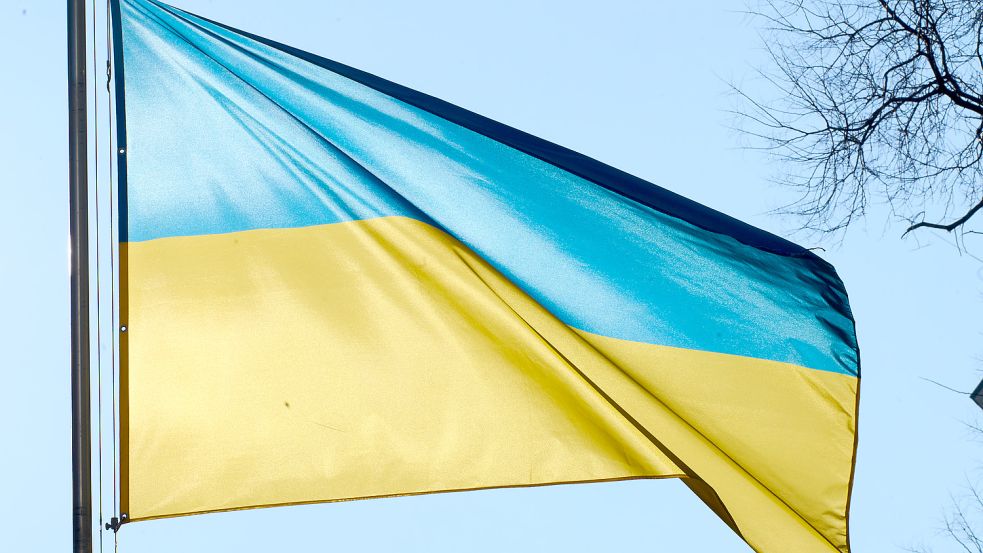 Die ukrainische Flagge weht vor der ukrainischen Botschaft in Berlin: In Berlin kommen derzeit viele Kriegsflüchtlinge aus der Ukraine an. Reißt russische Angriff in der Ukraine auch Gräben in Südoldenburg auf? Eine Spurensuche zwischen Küstenkanal und Dammer Bergen. Foto: Riedl/DPA