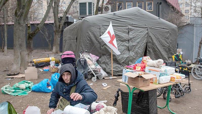 Ein Freiwilliger verteilt Kleidung an fliehende Bürger in der ukrainischen Stadt Irpin unweit von Kiew. Foto: Seth Sidney Berry/ZUMA Press Wire Service/dpa