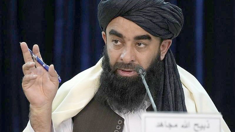 Taliban-Sprecher Sabiullah Mudschahid während einer Pressekonferenz. Foto: Hussein Malla/AP/dpa