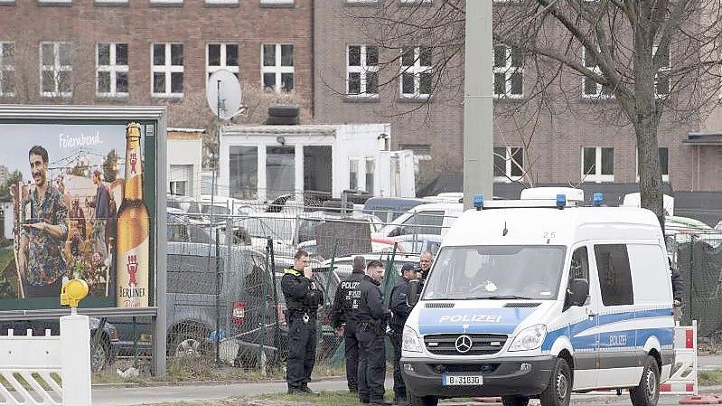 Polizeikräfte stehen vor dem Gelände eines Gebrauchtwagenhändlers. Dort fanden im Rahmen einer großangelegten bundesweiten Razzia Durchsuchungen statt. Foto: Paul Zinken/dpa