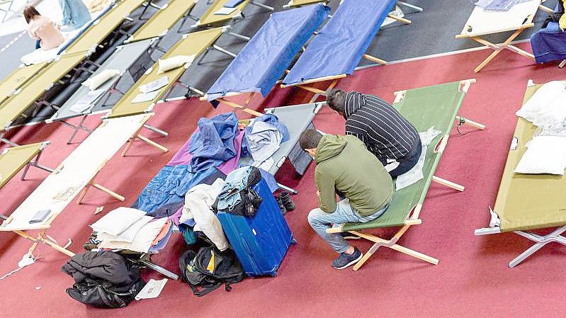 Geflüchtete sitzen in einer Unterkunft im niedersächsischen Landkreis Peine. Foto: Moritz Frankenberg/dpa