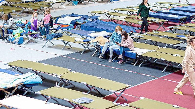 Geflüchtete aus der Ukraine sitzen in einer Flüchtlingsunterkunft im Landkreis Peine in Niedersachsen. Foto: Moritz Frankenberg/dpa