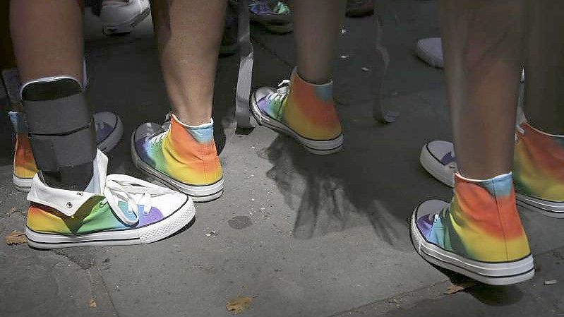 Teilnehmer des „Pride March“ in New York mit Turnschuhen in den Regenbogenfarben. Foto: Seth Wenig/AP/dpa