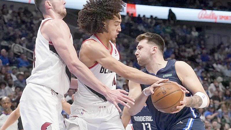 Portlands Drew Eubanks (l) und CJ Elleby (M) verteidigen gegen Luka Doncic von den Dallas Mavericks. Foto: Tony Gutierrez/AP/dpa