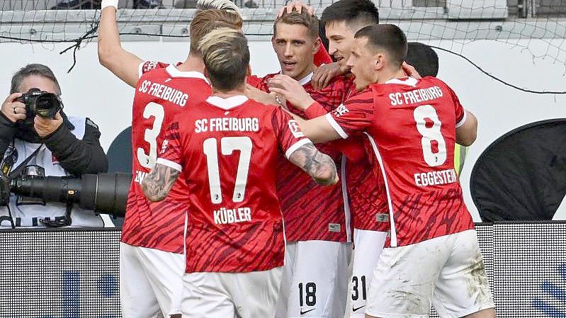 Freiburgs Spieler jubeln nach dem Tor zum 2:1 durch Nils Petersen (M). Foto: Arne Dedert/dpa