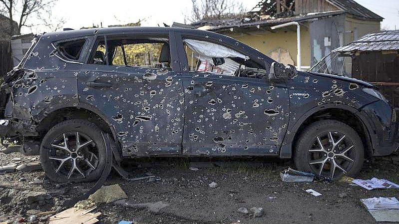 Ein von Einschusslöchern durchlöchertes Auto steht in Butscha am Straßenrand. Foto: Rodrigo Abd/AP/dpa