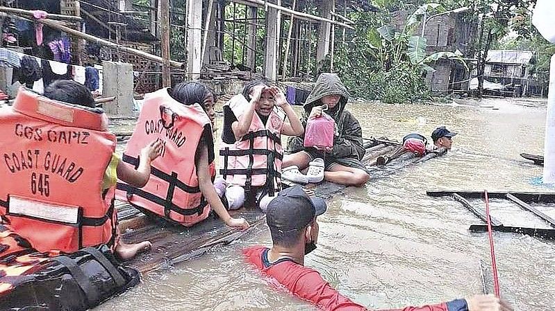 Retter evakuieren die Bewohner eines überschwemmten Dorfes in Panitan auf der Insel Panay. Foto: Uncredited/Philippine Coast Guard/AP/dpa