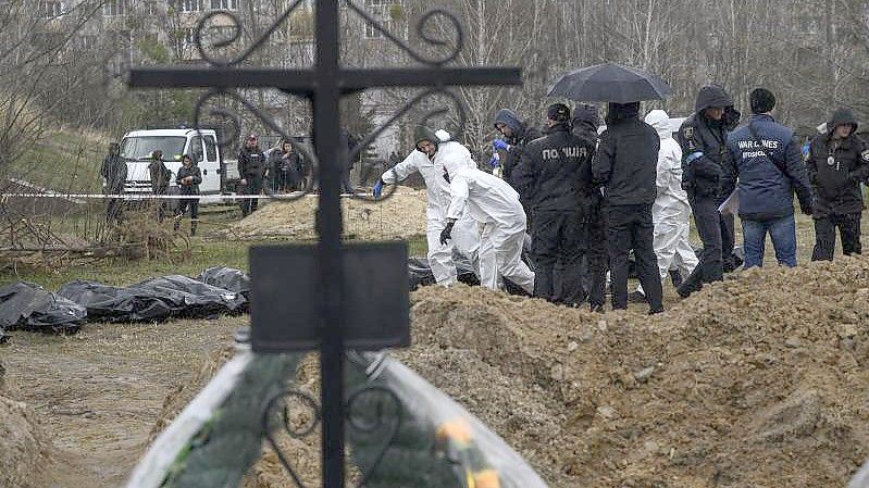 Personen in Schutzkleidung tragen die Leichen getöteter Zivilisten in Butscha am Stadtrand von Kiew. Foto: Valeria Ferraro/ZUMA Press Wire/dpa/Archiv