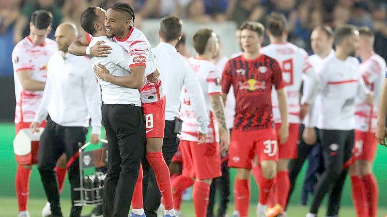 Leipzigs Christopher Nkunku jubelt mit Trainer Domenico Tedesco (l) nach dem Sieg in Bergamo. Foto: Jan Woitas/dpa