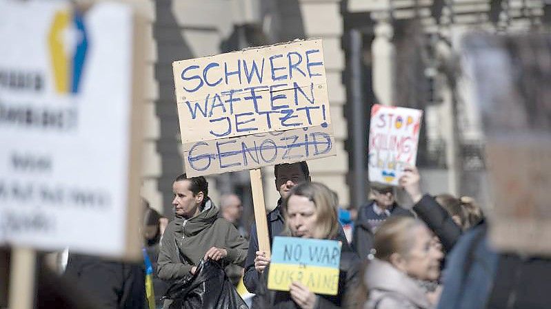 „Schwere Waffen jetzt“ steht auf einem Plakat bei einer Demonstration gegen den Krieg in der Ukraine in Berlin. Foto: Paul Zinken/dpa