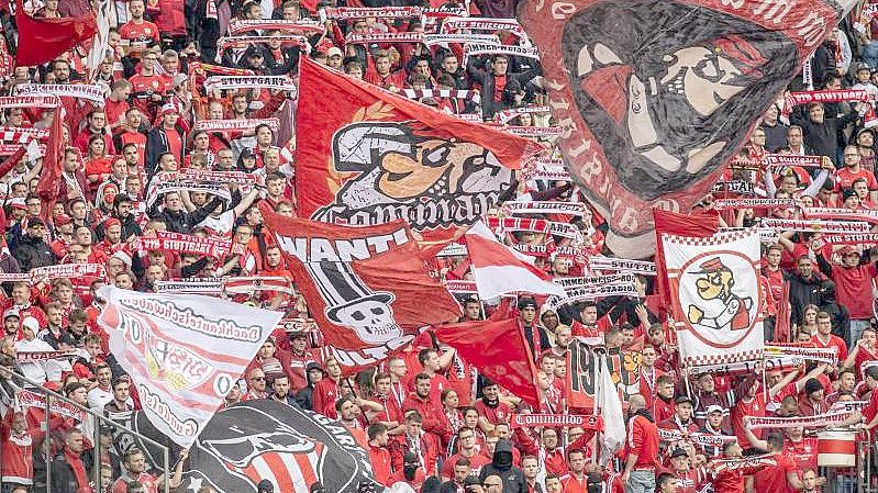 Fans von VfB Stuttgart feuern ihr Team aus dem Gästeblock des Olympiastadions an. Foto: Andreas Gora/dpa