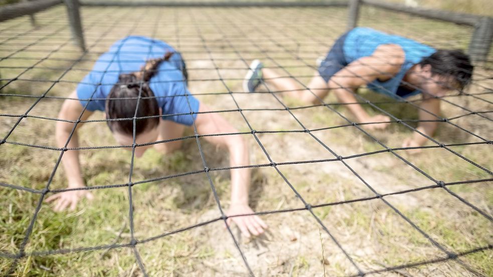 Wer den Wettbewerb um den Ostfriesland-Warrior gewinnen will, muss unter anderem unter einem gespannten Netz hindurchkriechen. Symbolfoto: WavebreakMediaMicro/stock.adobe.com