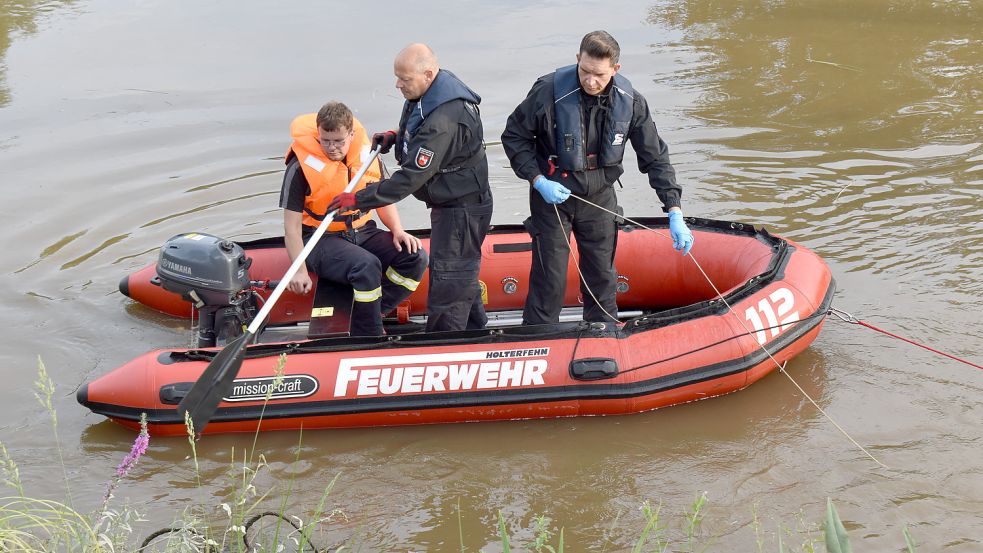 Die Sprengmeister Jörg Lange-Chudziak (rechts) und Michael Crölle haben am Mittwoch in der Leda bei Potshausen nach einer möglichen Granate gesucht. Zum Einsatz kam dabei auch das Rettungsboot der Feuerwehr, das von Hendrik Willms von der Holterfehner Wehr (links) gesteuert wurde. Foto: Zein