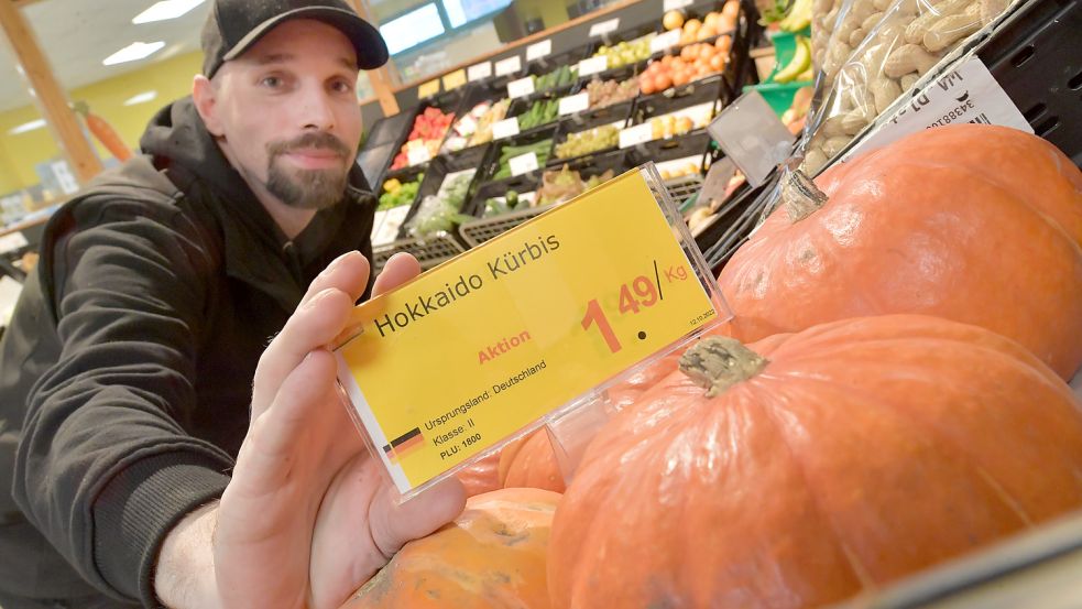 Günstiger als im Supermarkt: Verkäufer Dustin Heyn zeigt den Preis, den man derzeit in Kücks Biomarkt zahlt. Foto: Ortgies